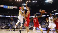 Stephen Curry #30 memberikan umpan kepada rekannya saat diadang para pebasket Houston Rockets pada laga perdana NBA 2017 di Oracle Arena, Oakland, (17/10/2017).  Rockets menang 122-121. Rockets menang 122-121. (Ezra Shaw/Getty Images/AFP)