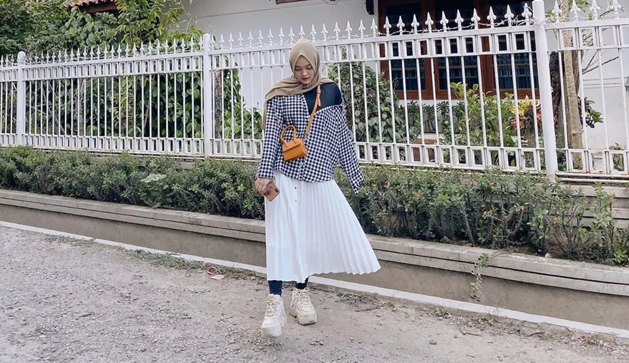 Putri Delina Andriyani, memang kerap membagikan outifit yang ia pakai di media sosialnya. Salah satunya saat ia memakai kemeja over-size yang dipadukan dengan rok panjang berwarna putih. Tas selmpang warna coklat menjadi tambahan penampilanny yang catchy.(Liputan6.com/IG/@putridelinaa)