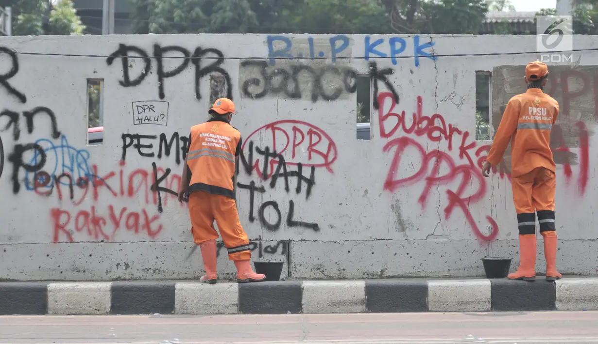 Petugas PPSU mengecat coretan yang mengotori tembok di kawasan Gedung DPR, Jakarta, Rabu (25/9/2019). Demonstrasi mahasiswa yang berujung ricuh yang berujung kerusuhan tersebut menyebabkan fasilitas umum rusak dan penuh coretan yang dibuat oleh pendemo. (merdeka.com/Iqbal S Nugroho)