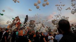 Sejumlah balon diterbangkan dalam upacara untuk memperingati peristiwa ledakan pelabuhan 4 Agustus di Beirut, Lebanon, 4 Oktober 2020. Dua ledakan yang mengguncang Pelabuhan Beirut menghancurkan sebagian kota dan menewaskan sekitar 190 orang serta melukai 6.000 lainnya. (Xinhua/Bilal Jawich)