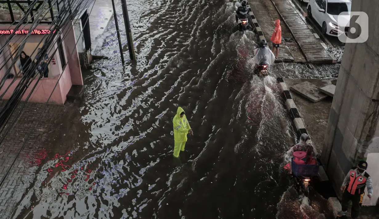 Petugas mengatur lalu lintas saat banjir menggenangi kawasan Seskoal - Cipulir, Jakarta, Selasa (4/4/2022). Hujan yang mengguyur wilayah Ibu Kota Jakarta mengakibatkan banjir menggenangi kawasan Simpang Seskoal, Kebayoran Lama, Jakarta. Banjir setinggi 50cm - 1 meter disebabkan saluran pembuangan berukuran kecil tersumbat. (Liputan6.com/Johan Tallo)