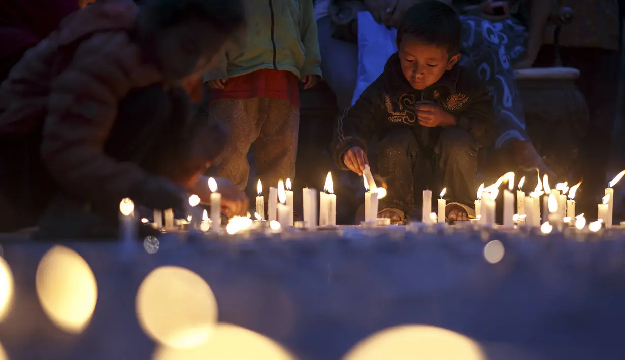 Puluhan lilin dinyalahkan oleh sejumlah anak untuk menghormati para korban gempa Nepal di Boudha Stupa, Kathmandu, Nepal, (7/5/2015). Gempa berkekuatan 7,8 yang meluluhlantakkan Nepal pada 25 April 2015 lalu. (REUTERS/Athit Perawongmetha)