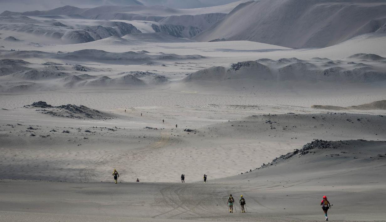 Para peserta berjalan saat mengikuti lomba marathon sejauh 250 kilometer di Gurun Ica, Kamis (30/11/2017). Marathon yang terbagi dalam enam tahapan ini diprediksi akan berakhir pada 4 Desember. (AFP/Jean-Philippe Ksiazek)