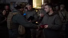 Presiden Ukraina Volodymyr Zelenskyy (kanan) memberikan penghargaan kepada seorang tentara di lokasi pertempuran terberat melawan Rusia di Bakhmut, Ukraina, 20 Desember 2022. Volodymyr Zelenskyy melakukan kunjungan mendadak ke Bakhmut. (Ukrainian Presidential Press Office via AP)