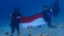 Penyelam membentangkan bendera Merah Putih seusai melakukan transplantasi terumbu karang di Pulau Pangempa, Kepulauan Togean, Kamis (6/9). Kegiatan ‘Tour de Terumbu’ ini dilakukan di 3 lokasi wilayah Sulawesi Tenggara. (Liputan6.com/Pool/Pertamina)