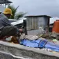 Seorang pria berduka atas jenazah korban gempa di Kota Mamuju, Sulawesi Barat, Indonesia, Jumat (15/1/2021). BMKG menyebut pusat gempa berada di darat, 6 kilometer timur laut Majene pada kedalaman 10 kilometer. (Firdaus/AFP)