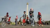 Suasana di kawasan Munomen Nasional (Monas) saat libur lebaran, Jakarta, Kamis (7/7). Libur kedua Lebaran ini dimanfaatkan warga untuk bekunjung ke lokasi wisata bersama keluarga. (Liputan6.com/Yoppy Renato)