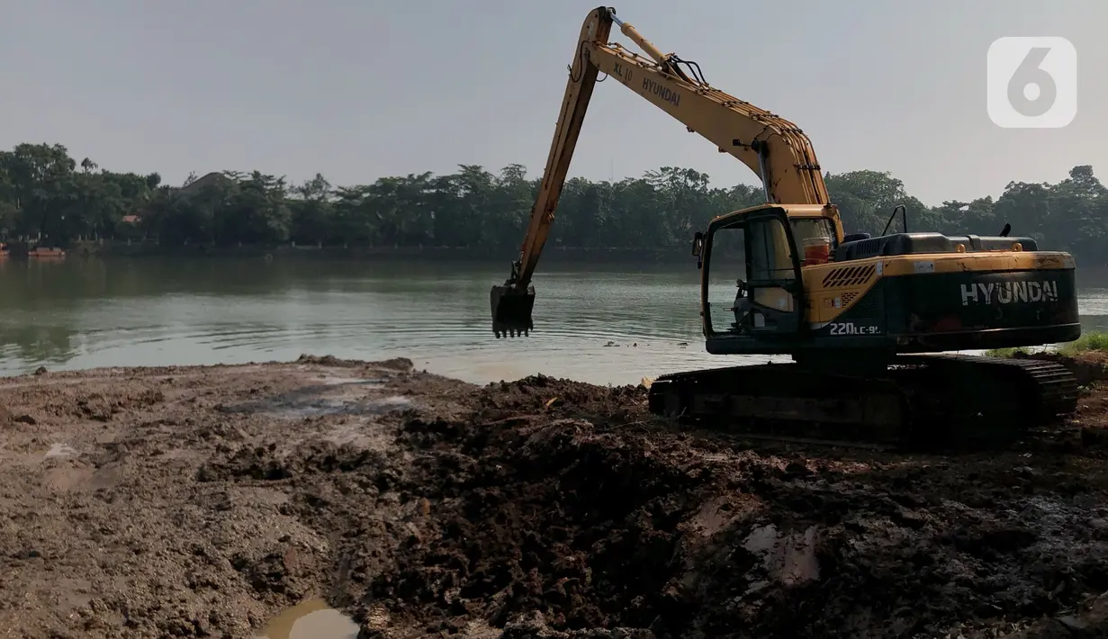Petugas menggunakan alat berat untuk mengeruk lumpur di Setu Babakan, Jakarta, Selasa (30/6/2020). Pengerukan dilakukan guna mengembalikan kedalaman setu sehingga menambah daya tampungnya. (Liputan6.com/Immanuel Antonius)