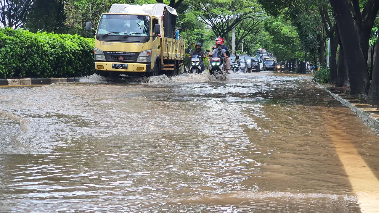 Pengendara melintasi genangan air di Jalan Raya Juanda Kota Depok, Sabtu (20/2/2021).