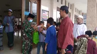 Aparat TNI membagikan masker kepada beberapa jemaah masjid di Bekasi yang kedapatan tidak memakainya, terutama anak-anak. (Liputan6.com/Bam Sinulingga)