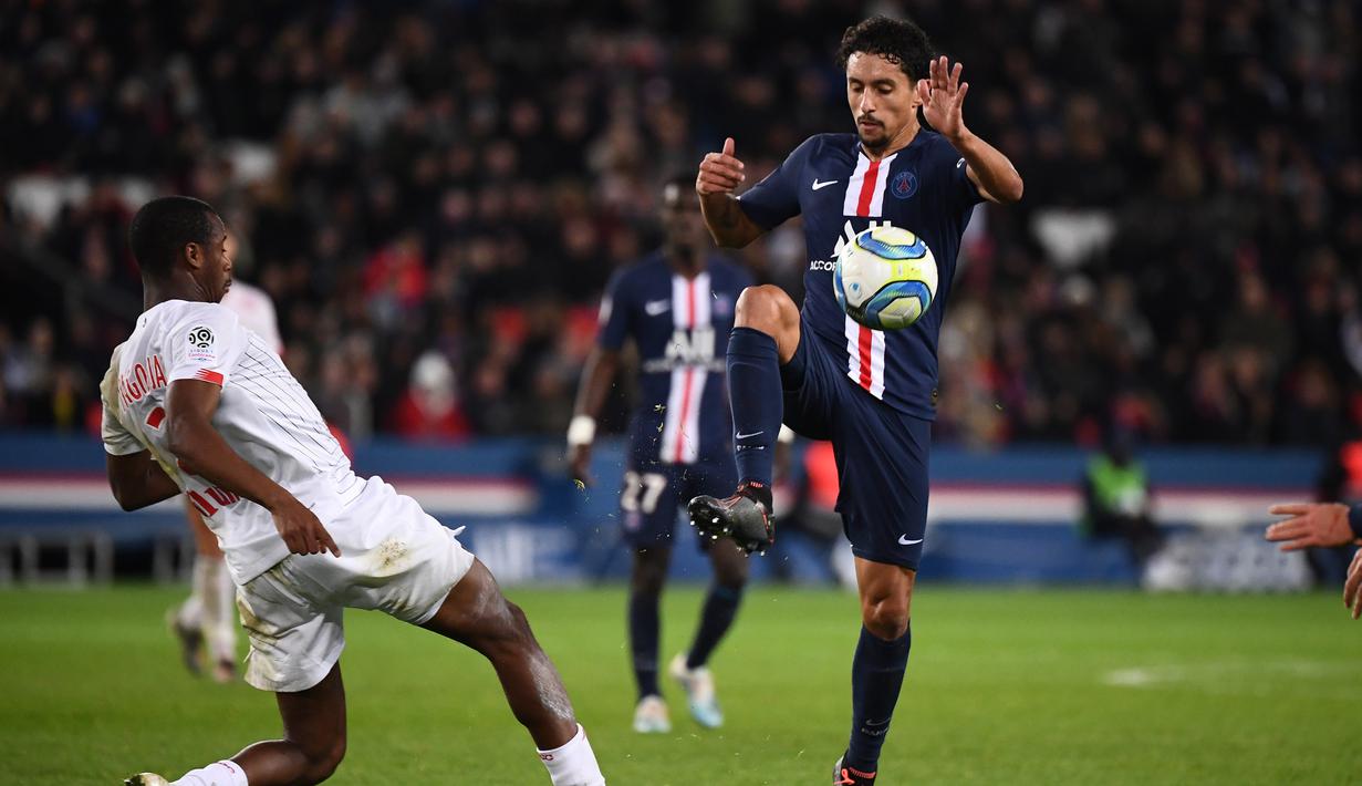 Bek PSG, Marquinhos, berebut bola dengan bek Lille, Tiago Djalo, pada laga Ligue 1 Prancis di Stadion Parc des Princes, Paris, Jumat (22/11). PSG menang 2-0 atas Lille. (AFP/Franck Fife)