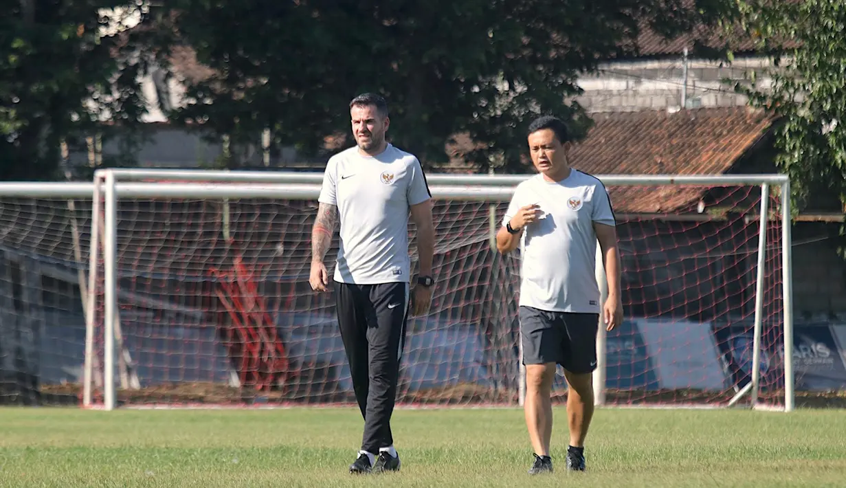 Pelatih Timnas Indonesia, Simon McMenemy, berdiskusi dengan Yeyen Tumena  saat latihan di Lapangan Gelora Trisakti, Bali, Minggu (13/10). Latihan ini merupakan persiapan jelang laga Kualifikasi Piala Dunia 2022 melawan Vietnam. (Bola.com/Aditya Wany)