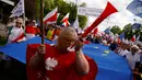 Seorang wanita ikut ambil bagian dalam pawai di jalanan Warsaw, Polandia, Sabtu (7/5). Ribuan warga turun ke jalan memprotes pemerintahan baru Polandia yang dipegang oleh partai konservatif. (REUTERS/Kacper Pempel)