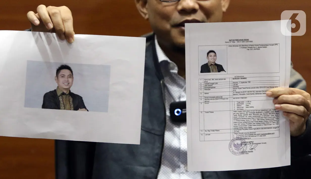 Pelaksana tugas (Plt) Juru Bicara KPK, Ali Fikri menunjukkan data diri Bupati Tanah Bumbu periode 2010-2015 dan 2016-2018, Mardani H. Maming saat mengumumkan status Daftar Pencarian Orang (DPO), Gedung KPK, Jakarta, Selasa (26/7/2022). Mardani H Maming terjerat dalam kasus dugaan suap dan gratifikasi terkait izin usaha pertambangan di Kabupaten Tanah Bumbu, Kalimantan Selatan. (Liputan6.com/Helmi Fithriansyah)