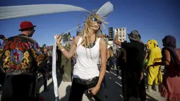 Lauren Gilligan menari di depan instalasi Robot Heart dalam festival musik dan seni Burning Man 2015 di Gurun Black Rock, Nevada, (1/9/2015). Partisipan dari seluruh dunia hadiri festival seni unik ini selama sepekan. (REUTERS/Jim Urquhart)