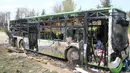 Kondisi bus yang membawa pengungsi Suriah usai terkena serangan bom di Rasyidin, Aleppo, Suriah, Minggu (16/4). Serangan bom tersebut diperkirakan telah menewaskan 126 orang. (AFP Photo/Omar Haj Kadour)