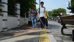 Penyandang disabilitas netra berjalan menyusuri ubin pemandu saat kampanye kegunaan ubin pemandu di trotoar Rawamangun, Jakarta, Selasa (2/4/2019). Kegiatan tersebut untuk memberikan pemahaman kepada masyarakat luas agar tidak terjadi penyalahgunaan di area ubin pemandu. (merdeka.com/Imam Buhori)