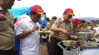 Menteri Sosial Idrus Marham mencicipi makanan di lokasi pengungsian bencana gempa di Desa Kuta, Kecamatan Megamendung, Kabupaten Bogor, Sabtu (27/1/2018). (Liputan6.com/Achmad Sudarno)