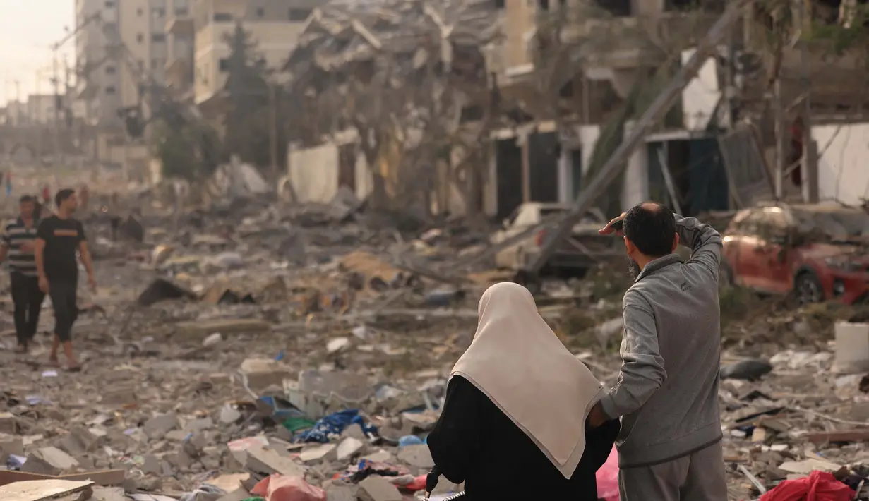 Warga Palestina memeriksa kehancuran besar-besaran akibat serangan udara Israel di distrik al-Rimal, Kota Gaza, pada 10 Oktober 2023. (MAHMUD HAMS/AFP)