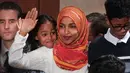 Senator Amerika Serikat (AS) Ilhan Omar melambaikan tangan saat mengikuti pelantikan di Gedung Kongres AS, Capitol, Washington, Kamis (3/1). Omar adalah perempuan berhijab pertama yang masuk ke Senat AS. (Glen Stubbe/Star Tribune via AP)