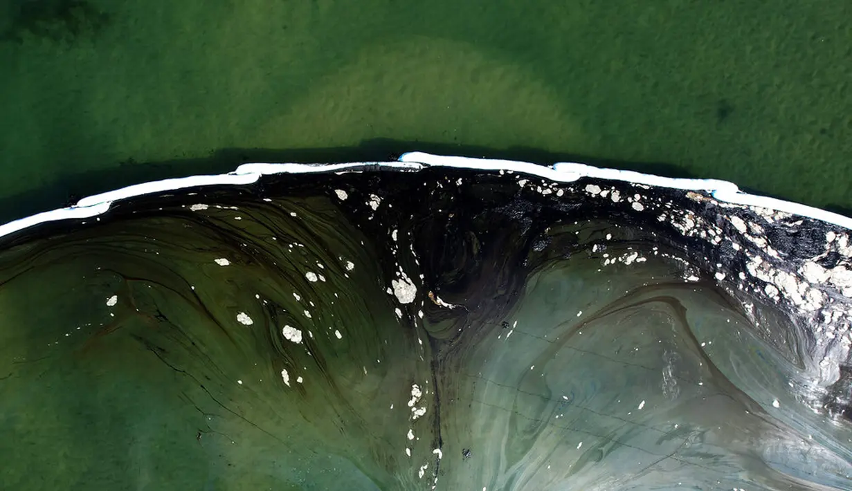 Foto udara menunjukkan penghalang dibuat untuk mencoba menghentikan tumpahan minyak ke Wetlands Talbert Marsh di Huntington Beach, California, Amerika Serikat, 4 Oktober 2021. Tumpahan sekitar 480 liter minyak mencemari laut dan pantai di California. (AP Photo/Ringo H.W. Chiu)
