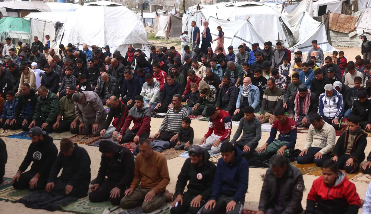 Seperti yang terlihat di sekitar Masjid Al-Talbani, yang dihancurkan oleh militer Israel di Khan Yunis, Jalur Gaza selatan. Tampak dalam foto, warga Palestina berdoa saat salat Jumat terakhir di bulan suci Ramadan 1447 Hijriah, di luar Masjid Al-Talbani, yang dihancurkan oleh militer Israel di Khan Yunis, Jalur Gaza selatan pada Jumat 13 Maret 2026. (Bashar Taleb/AFP)