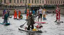 Seorang wanita membawa anjingnya mendayung "paddle board" di kanal Griboedov pada festival SUP (Stand Up Paddle)-Surfing di St.Petersburg, Rusia, Minggu (12/8). Dalam paddling, papan digerakkan dengan cara mendayung sambil berdiri. (AP/Dmitri Lovetsky)