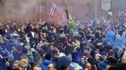 Suporter merayakan kemenangan usai klub sepak bola kebanggan mereka, Rangers menjuarai Liga Skotlandia 2020/2021. Ini merupakan gelar juara liga pertama bagi The Gers dalam 10 tahun terakhir. (Foto: AFP/Andy Buchanan)