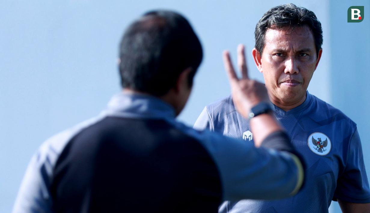 Asisten Pelatih Timnas Indonesia U-22, Bima Sakti, berbincang dengan Indra Sjafri, saat sesi latihan Jelang persiapan SEA Games 2023 di Lapangan A Senayan, Jakarta, Selasa (7/3/2023). (Bola.com/M Iqbal Ichsan)