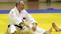 Presiden Vladimir Putin melakukan pemanasan sebelum mengikuti sesi latihan judo bersama atlet nasional Rusia di Sochi, Kamis (14/2). Judo merupakan salah satu olahraga kegemaran Putin yang telah digeluti sejak masa muda. (Mikhail KLIMENTYEV/SPUTNIK/AFP)
