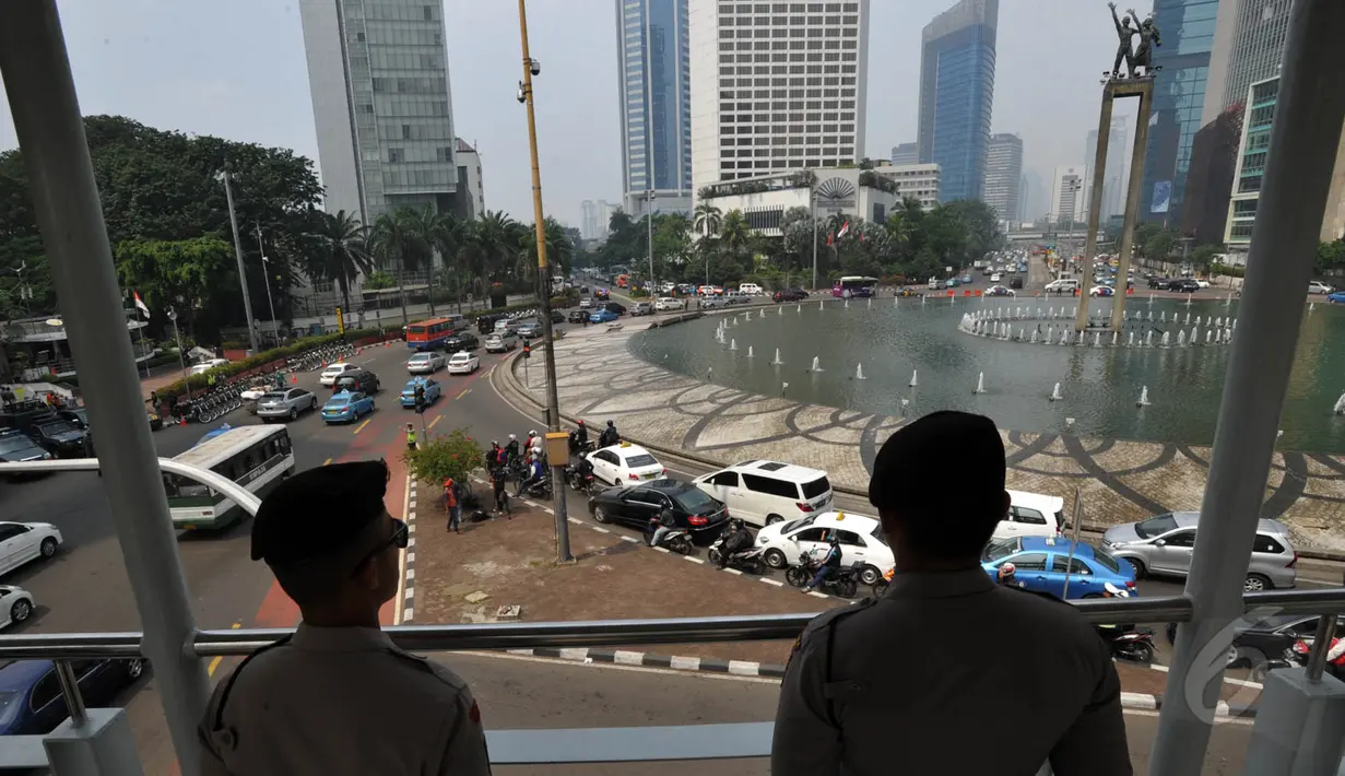Sejumlah petugas kepolisian tampak berjaga di JPO sekitar Bundaran Hotel Indonesia, Jakarta (20/5/2015). Penjagaan ini berkaitan dengan akan dilaksanakannya aksi ribuan mahasiswa di depan Istana Presiden. (Liputan6.com/Johan Tallo)