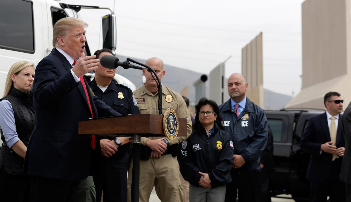 Presiden AS, Donald Trump memberikan keterangan kepada awak media seusai meninjau prototipe tembok perbatasan AS dan Meksiko di San Diego, Selasa (13/3). Tembok setinggi 30 kaki itu dibangun Trump untuk mencegah masuknya imigran gelap. (AP/Evan Vucci)