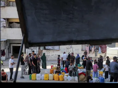 Orang-orang yang terlantar akibat perang menunggu dengan wadah air untuk mengisi persediaan mereka dari tangki air di kamp penampungan, Khan Yunis, Jalur Gaza Selatan pada 6 Juni 2026. (Bashar Taleb/AFP)