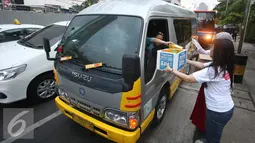 Karyawan Asia Pulp & Paper (APP) Sinar Mas membagikan takjil kepada pengendara di kawasan Bundaran HI, Jakarta (24/6). (Liputan6.com/ Immanuel Antonius)