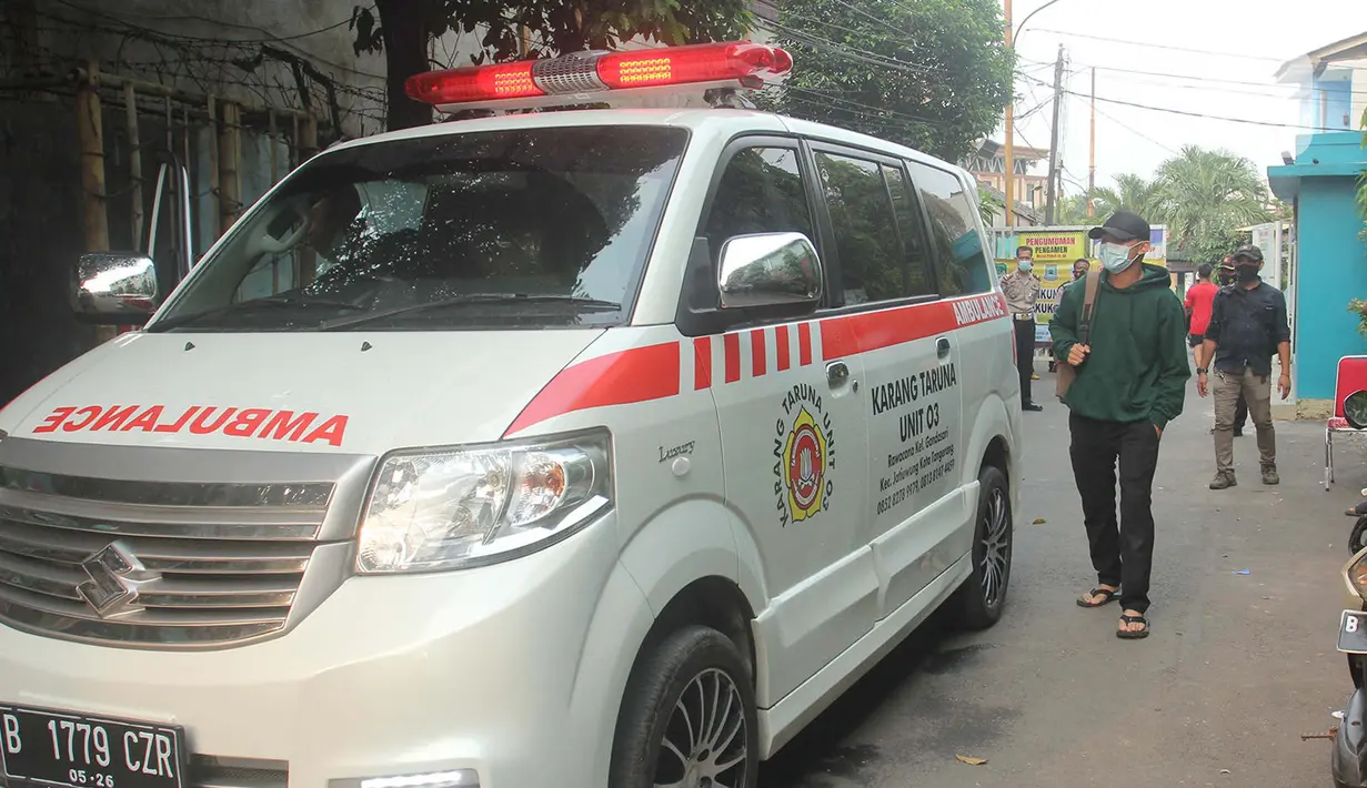 Warga melintas di dekat mobil ambulans di RW 03, Kelurahan Gandasari, Kecamatan Jatiuwung, Kota Tangerang, Rabu (9/6/2021). Pemerintah setempat menerapkan lockdown skala mikro setelah 57 warga di kawasan tersebut terkonfirmasi positif COVID-19. (Liputan6.com/Angga Yuniar)