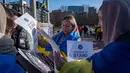 Pengunjuk rasa membagikan spanduk untuk memperingati tahun kedua invasi Rusia ke Ukraina dan sepuluh tahun Rusia mencaplok Krimea di Boston Common, Boston, Massachusetts, 24 Februari 2024. (Joseph Prezioso/AFP)