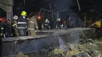 Petugas pemadam kebakaran Layanan Darurat Negara Ukraina bekerja untuk memadamkan api di pusat perbelanjaan yang terbakar setelah serangan roket di Kremenchuk, Ukraina, Senin malam (27/6/2022) malam. (AP Photo/Efrem Lukatsky)