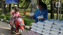Mahasiswa memberikan makanan gratis kepada masyarakat di UKI, Cawang, Jakarta, Selasa (16/3/2021). Kegiatan ini memberikan 500 bungkus nasi, masker dan vitamin setiap harinya sejak pukul 06.00 WIB, untuk meringankan beban masyarakat di masa pandemi Covid-19. (Liputan6.com/Herman Zakharia)