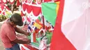 Penjual bendera musiman merapikan dagangannya di pinggir trotoar kawasan Pasar Minggu, Jakarta, Kamis (2/8). Menjelang perayaan HUT RI ke-73, sejumlah penjual bendera dan umbul-umbul mulai bermunculan di berbagai sudut Kota. (Liputan6.com/Herman Zakharia)