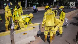 Petugas Dinas Bina Marga DKI Jakarta memperbaiki separator busway di kawasan Jalan Gatot Subroto, Jakarta, Selasa (1/10/2019). Separator busway dirusak massa saat terjadi bentrok antara polisi dengan demonstran di kawasan tersebut. (Liputan6.com/Faizal Fanani)