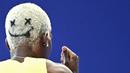 Rambut pelari Jamaika, Janieve Russell bergambar emoji wajah tersenyum saat berkompetisi dalam nomor lari gawang 400 meter Olimpiade Paris 2024 di Stade de France, Paris, Prancis, 6 Agustus 2024. (AFP/Jewel Samad)