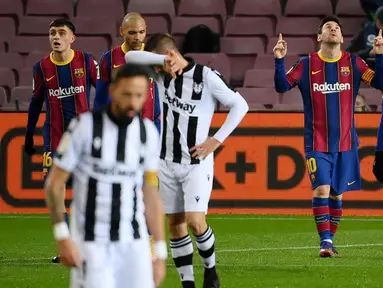 Striker Barcelona, Lionel Messi, melakukan selebrasi usai mencetak gol ke gawang Levante pada laga Liga Spanyol di Stadion Camp Nou, Senin (14/12/2020). Barcelona menang dengan skor 1-0. (AFP/Lluis Gene)