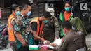 Petugas Satpol PP mendata warga yang terjarinng razia masker di kawasan Tanjung Duren, Jakarta, Kamis (19/11/2020). Satpol PP terus menindak warga yang melanggar protokol kesehatan selama PSBB transisi dengan sanksi kerja sosial di sarana umum atau membayar denda. (merdeka.com/Imam Buhori)