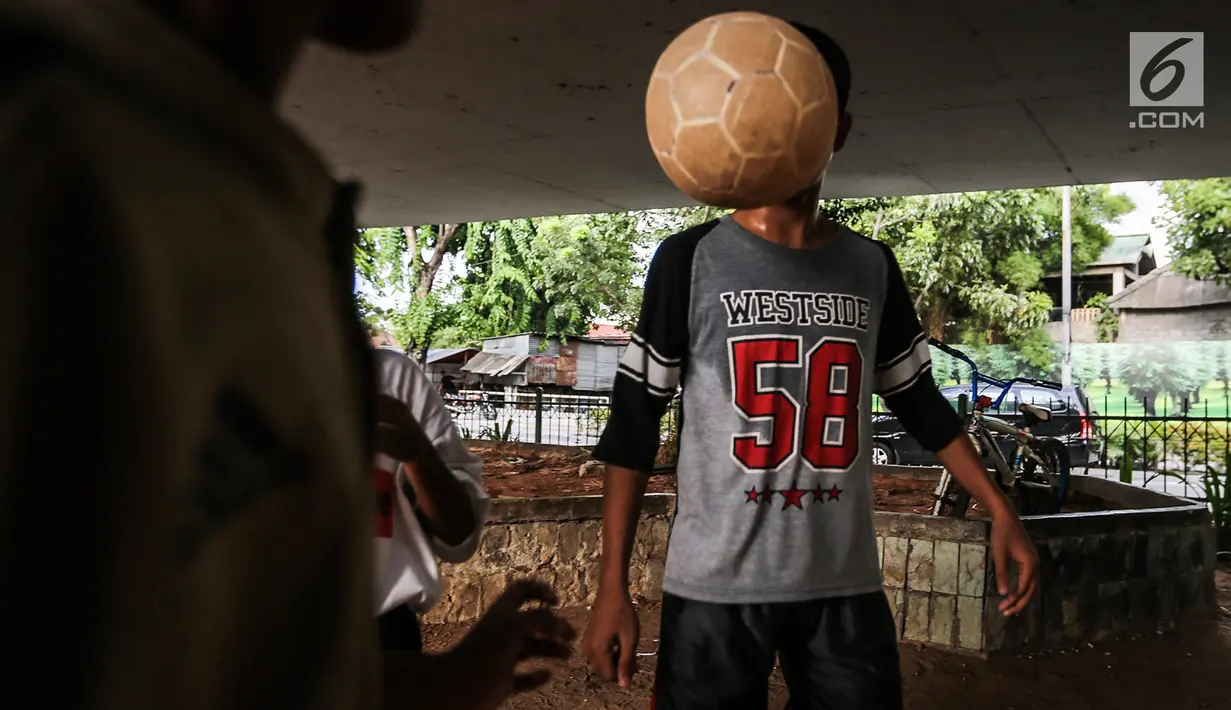 Anak-anak bermain sepak bola di kolong jembatan layang Tanah Abang, Jakarta, Kamis (15/11). Mereka memanfaatkan lahan kosong usai jam pulang sekolah. (Liputan6.com/Fery Pradolo)