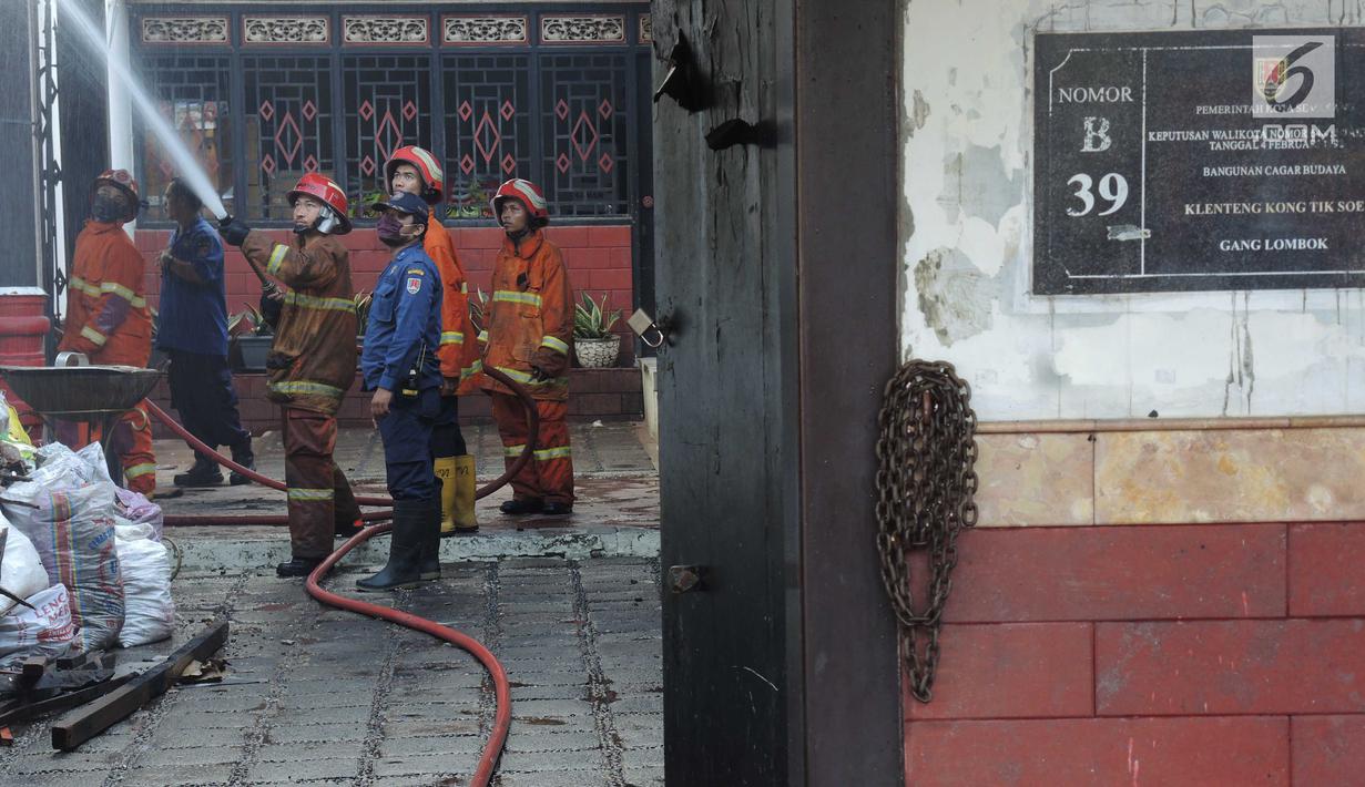 Petugas pemadam kebakaran memadamkan api yang membakar salah satu bangunan di kompleks Kelenteng Tay Kak Sie di Gang Lombok, Semarang, Kamis (21/3). Dilaporkan satu orang tewas dalam insiden kebakaran ini. (Liputan6.com/Gholib)