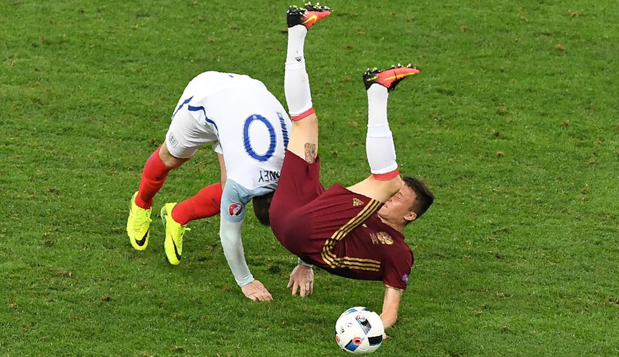 Striker Inggris, Wayne Rooney, duel dengan pemain Rusia, Aleksandr Golovin, pada laga Grup B Piala Eropa 2016 di Stade Velodrome, Marseille, Minggu (12/6/2016) dini hari WIB. (AFP/Boris Horvat)