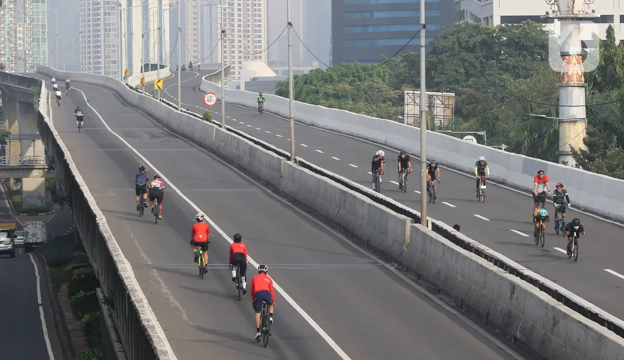 Sejumlah pengguna sepeda road bike melintas di Jalan Layang Non Tol (JLNT) Kampung Melayu-Tanah Abang, Jakarta, Minggu (30/5/2021). Dinas Perhubungan DKI Jakarta melakukan uji coba lintasan road bike JLNT Kampung Melayu-Tanah Abang tahap kedua pada pukul 05.00-08.00 WIB. (Liputan6.com/Herman Zakhari