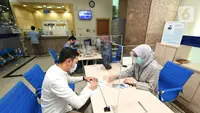 Nasabah Unit Usaha Syariah (UUS) PT Bank Tabungan Negara (Persero) Tbk. tengah melakukan transaksi di kantor BTN Syariah di Jakarta, Rabu (06/04/2021). BTN Syariah tetap mencatatkan pertumbuhan kinerja mencapai double digit kendati berada di masa pandemi. (Liputan6.com/Pool/BTN)