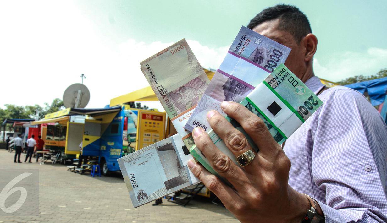 Warga menunjukkan uang pecahan Rupiah di layanan penukaran uang receh di Monas, Jakarta, Selasa (30/6). Bank Indonesia bekerjasama dengan 14 bank lainnya membuka loket penukaran uang pecahan kecil sejak 17 Juni-15 Juli 2015. (Liputan6.com/Faizal Fanani)