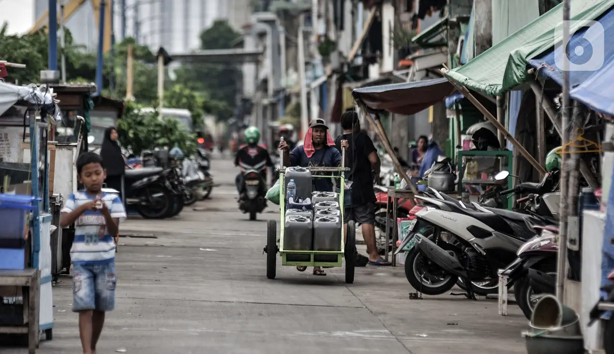Pedagang air keliling saat melintas di permukiman padat penduduk di Jakarta, Minggu (18/10/2020). Institute for Development of Economics and Finance (Indef) memproyeksikan jumlah penduduk miskin naik 1,63 juta jiwa atau 0,56 persen selama masa pandemi Covid-19. (merdeka.com/Iqbal S. Nugroho)